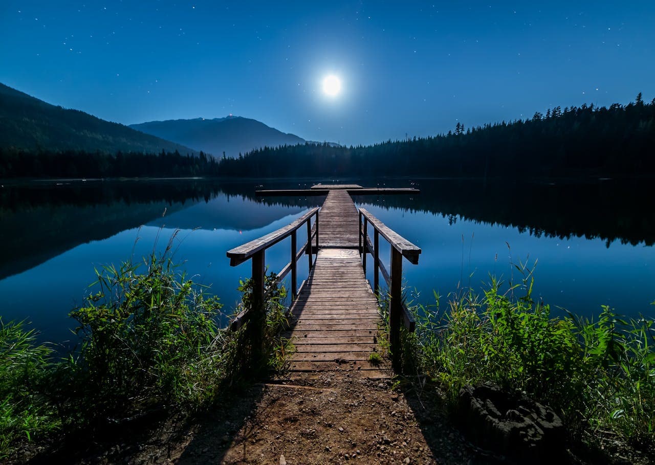 Muelle de madera sobre un lago de montaña de noche